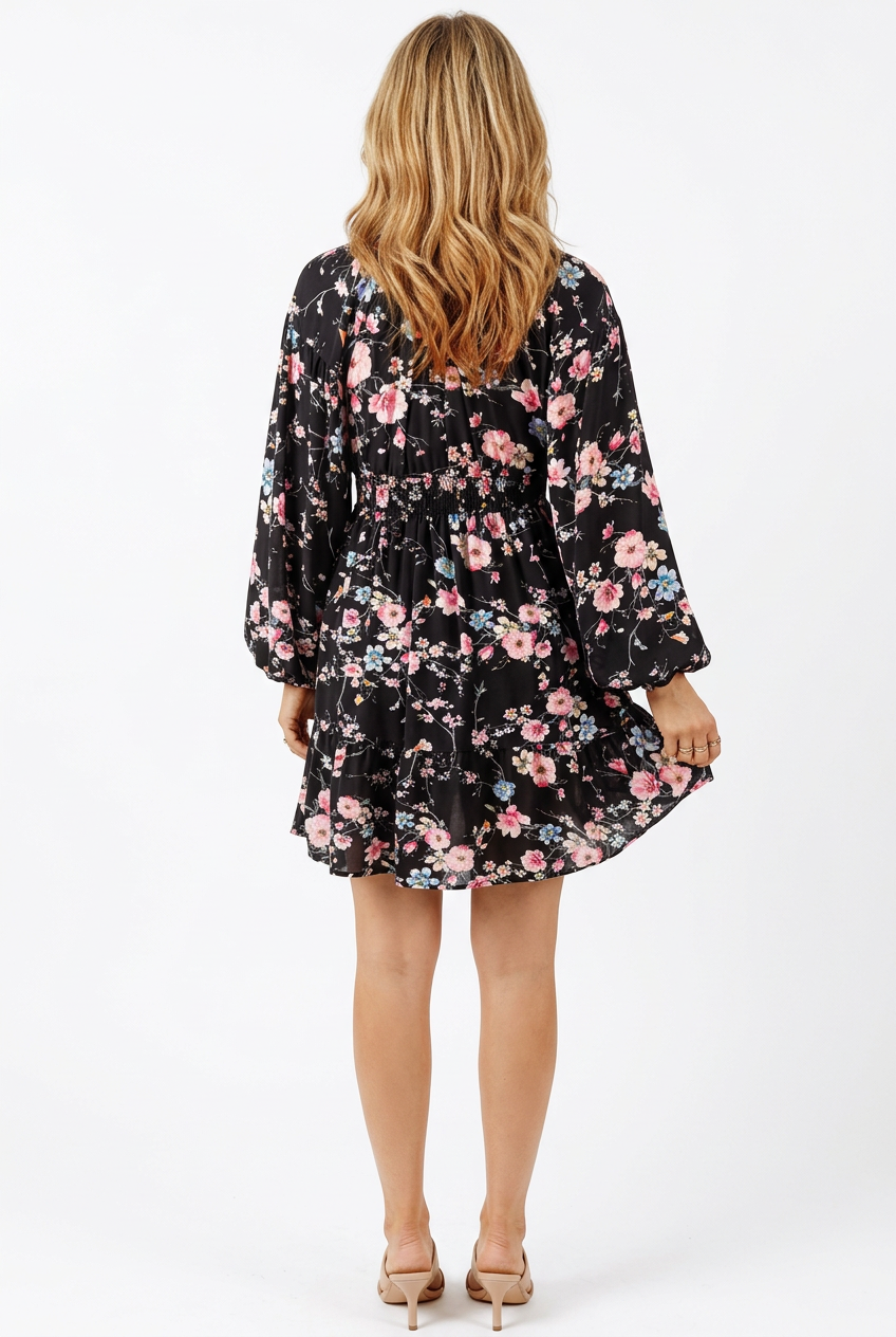 Black floral mini dress with elastic waist and long sleeves, full-body back view